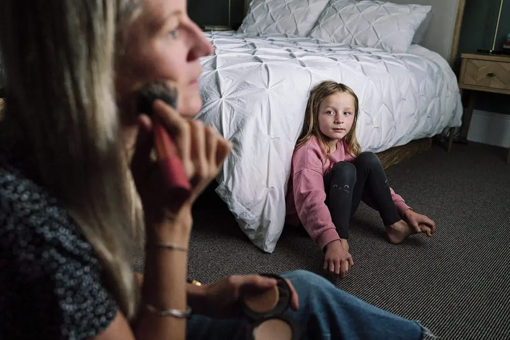 Daughter watching mum put on makeup in their East Dulwich family home — documentary family photography SE22