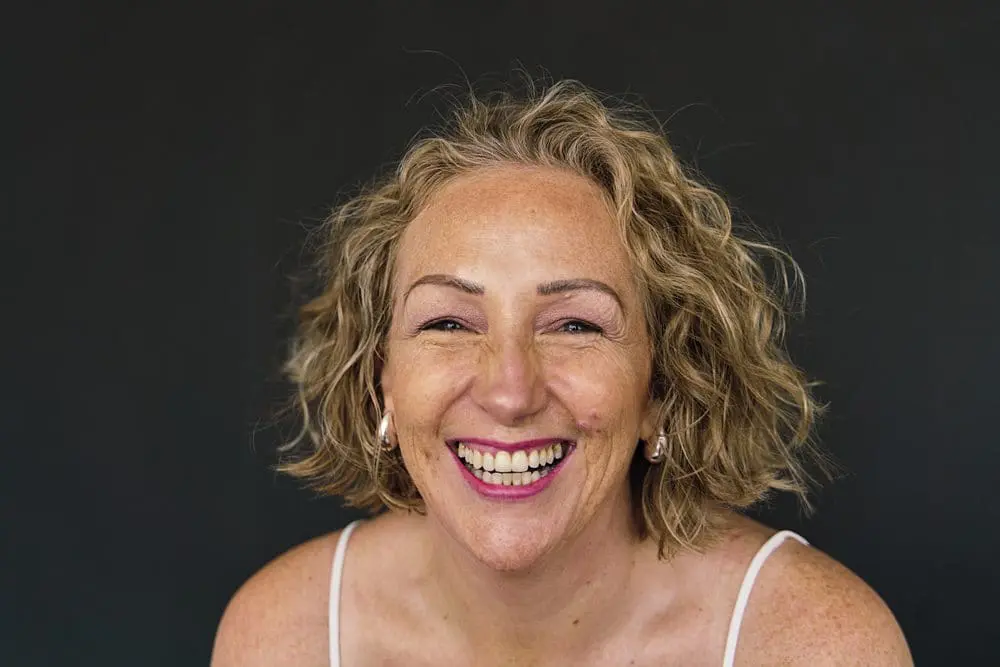 Woman with a genuinely warm smile looking into camera — relaxed mini headshot photography London