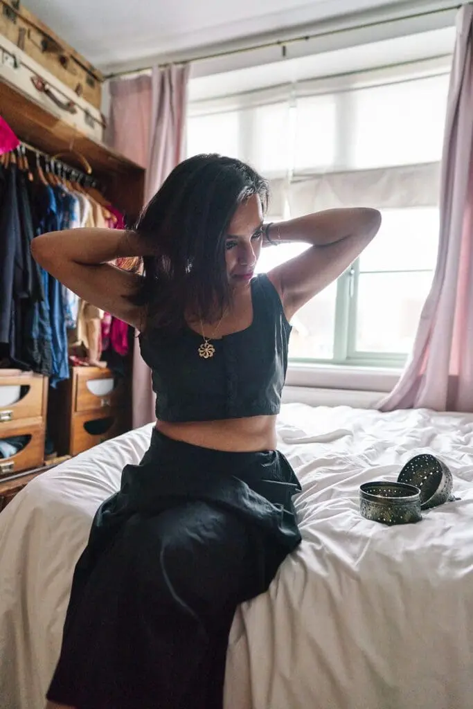 Freelancer getting ready at home putting on necklace — behind the scenes personal brand photoshoot London