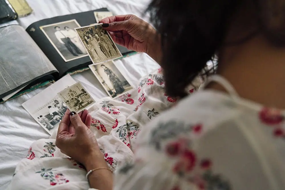 Doula business owner holding old family photographs — storytelling personal brand photography London