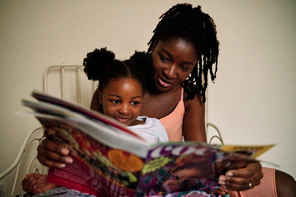 Mother and daughter reading a book during a natural family photography session in Rochester Kent