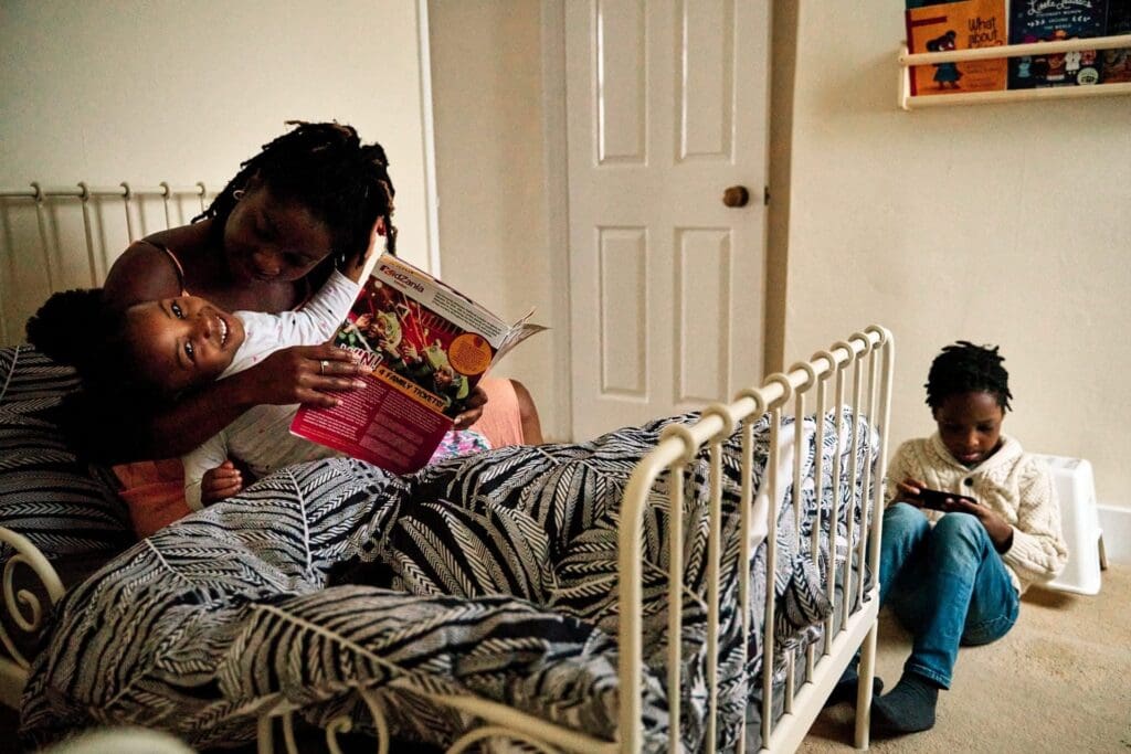 Mother and child reading together on the bed during a family photoshoot in Rochester Kent