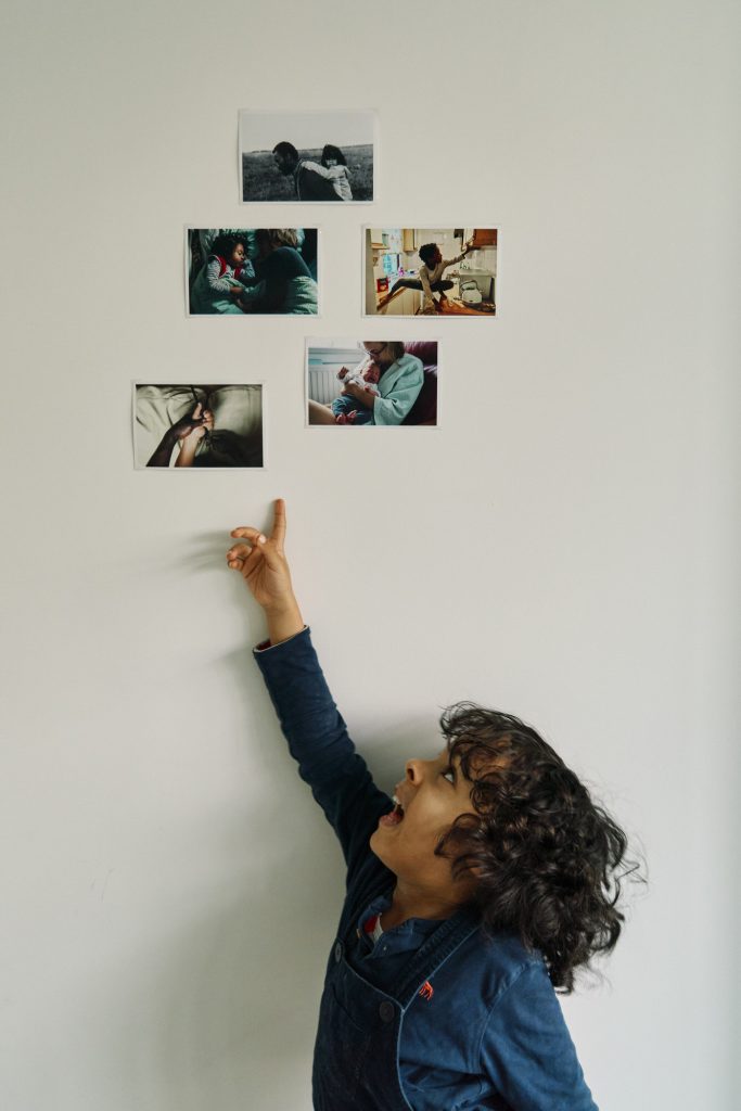 My son pointing to my 5 favourite photographs of 2020 hanging on the wall. 