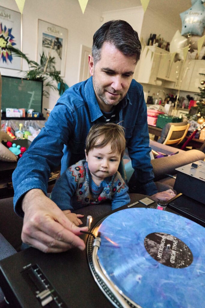 Dad playing record player during relaxed family photo shoot in London