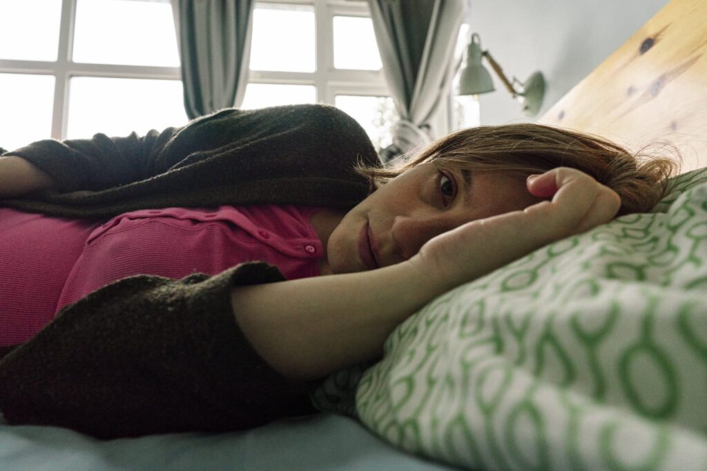 A self-portrait, while being pregnant lying on my bed showing what pregnancy is like through documentary maternity photography. 