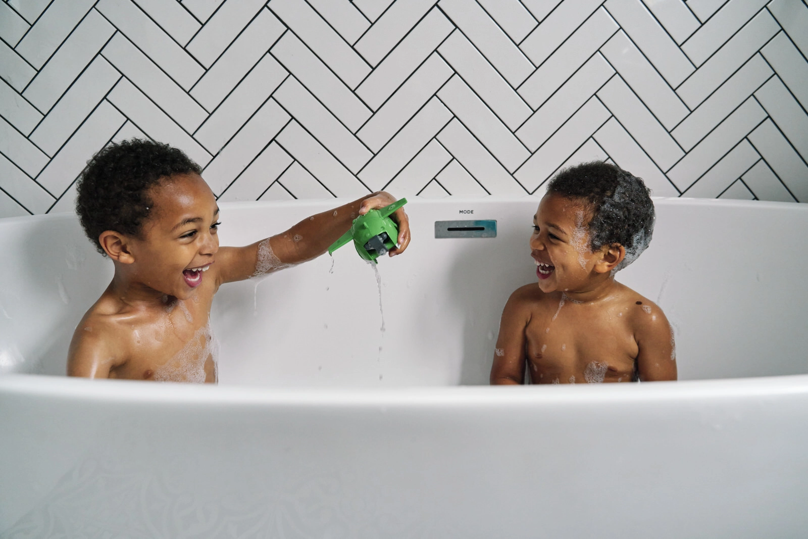 Siblings playing together in the bath — fun candid family photography East Dulwich SE22