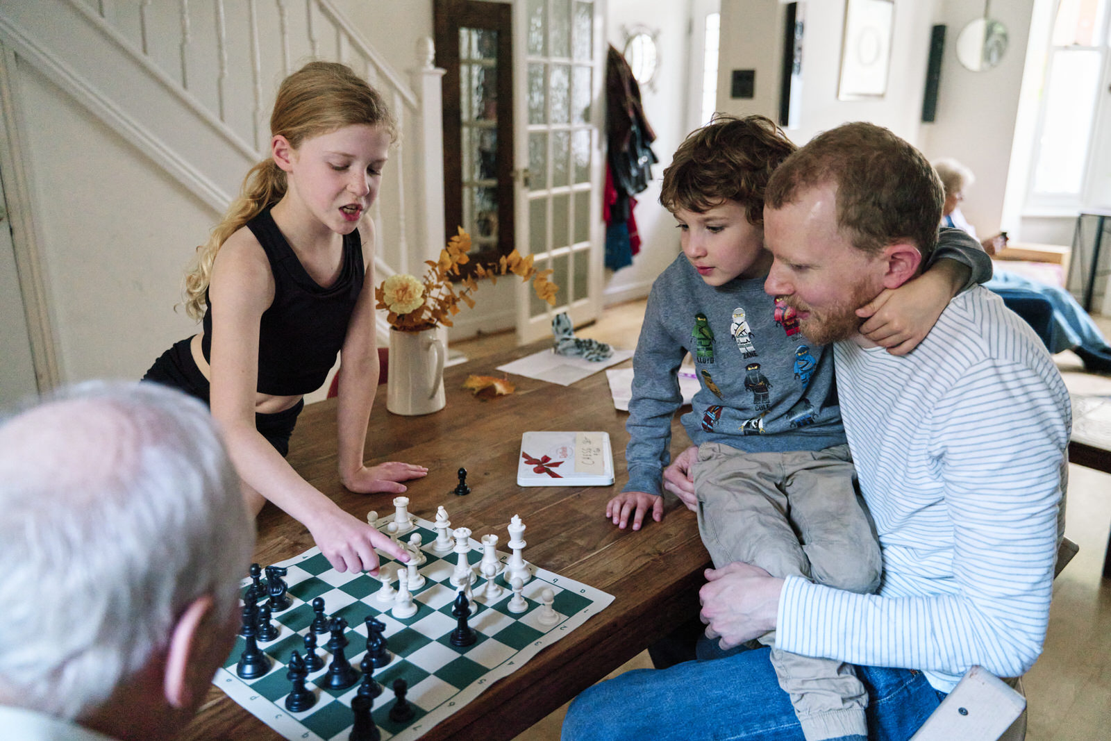 Family playing chess as a fun activity during a family photography shoot. 