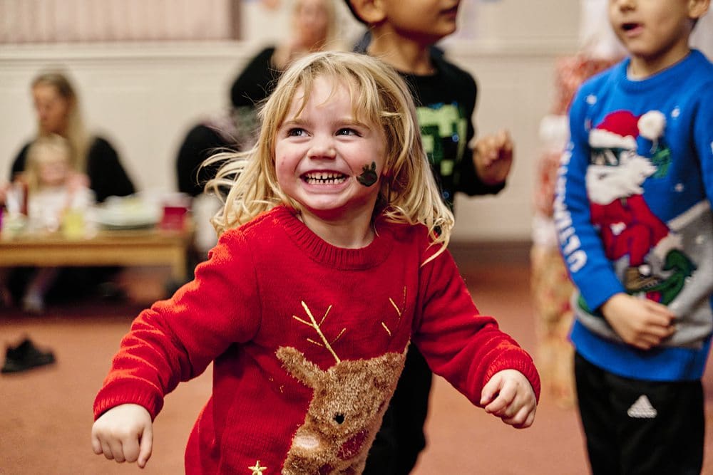 Ethical charity storytelling — documentary photograph showing small girl laughing with dignity and agency