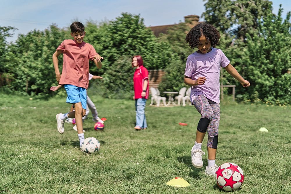 Kids playing football showing charity clients with dignity and agency in this photograph.