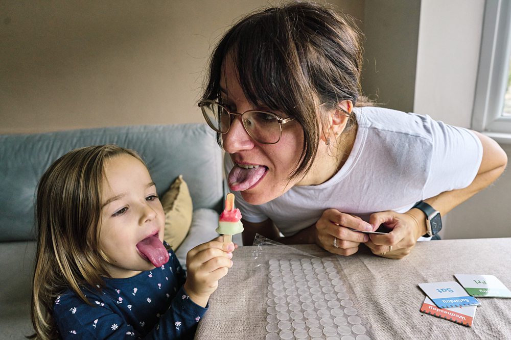 Mum eating ice-cream with her daughter during a documentary family photo session in London