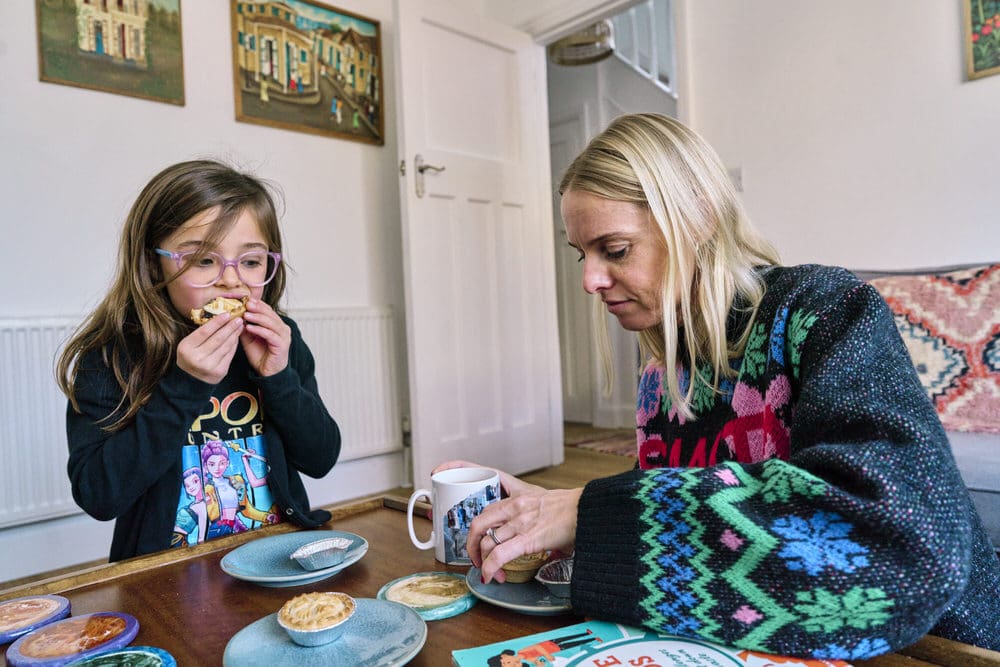 Mum and daughter eating mince pies together — candid Christmas family photography South-East London