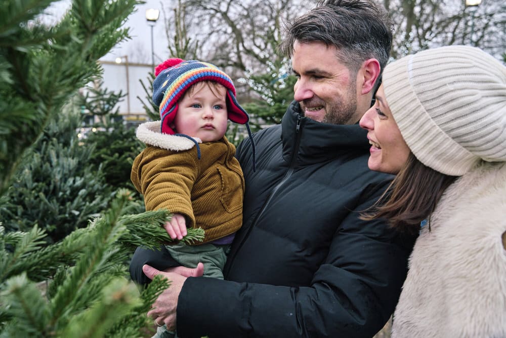 Family choosing a Christmas tree together at a farm — documentary Christmas family photography South-East London