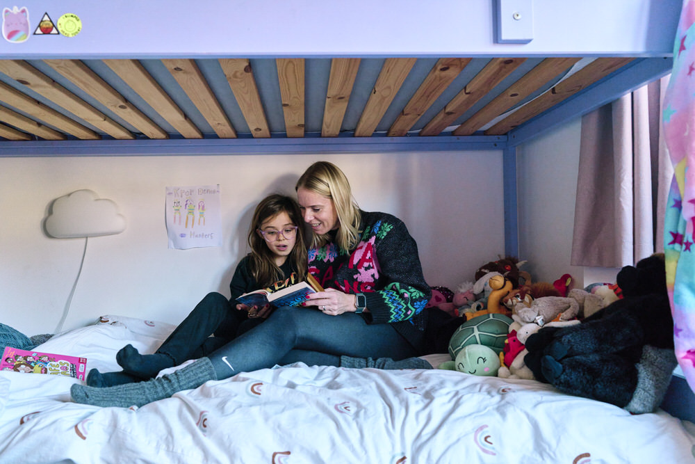 Documentary family photographer Saskia capturing real moments in a London family home of mother reading with daughter.