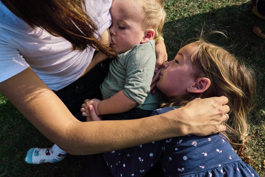 Parent breastfeeding child during natural family photography session in London.