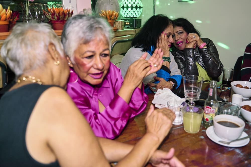 Documentary family event photography in London capturing candid moments of chatting during a celebration.