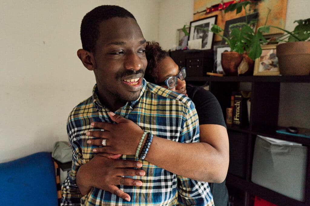 Neurodivergent-friendly family photography at home, authentic and documentary style, London where a mother gives her autistic son a big spontaneous hug.